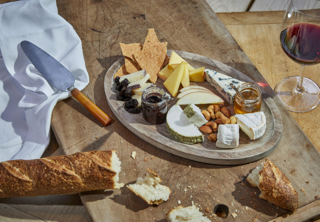 Plate of cheese with bread and a glass of wine